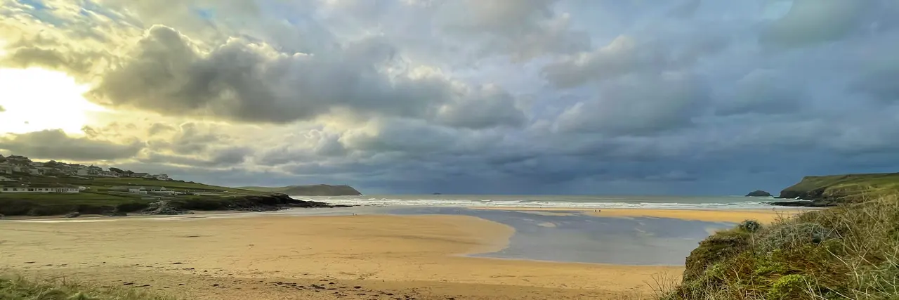 A winter view of Polzeath beach. On the left is the grass of Tristram field with Stepper Point beyond, while Pentire Point is on the right. The mouth of the River Camel is between.