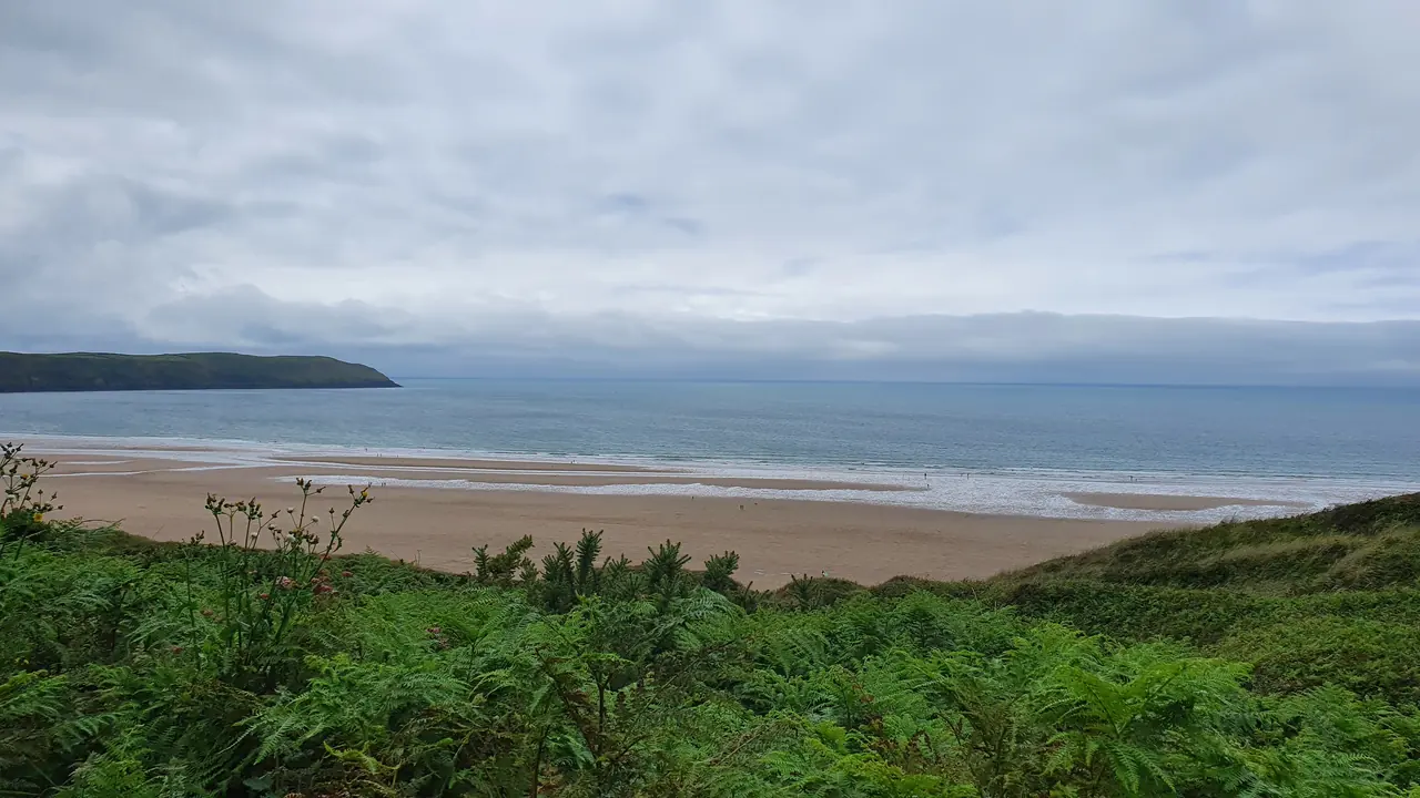 View of the beach from the sand dunes. Cloudy and overcast day in summer.