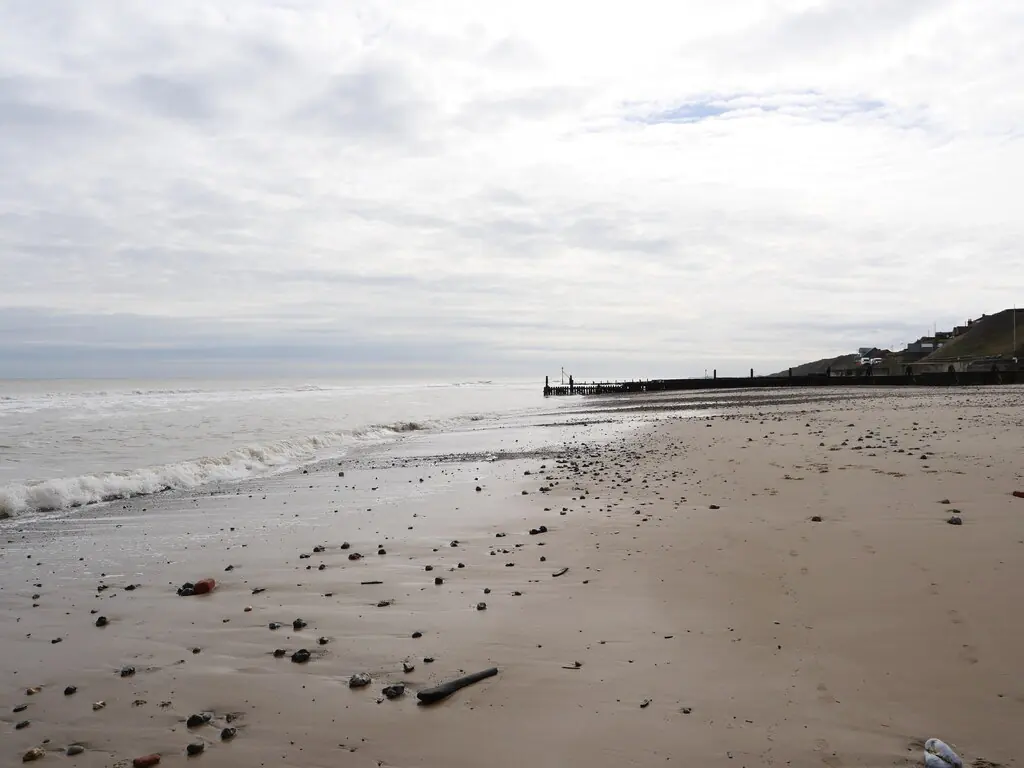 Looking south east along the shoreline of Mundesley beach located in the village of Mundesley , Norfolk, United Kingdom.