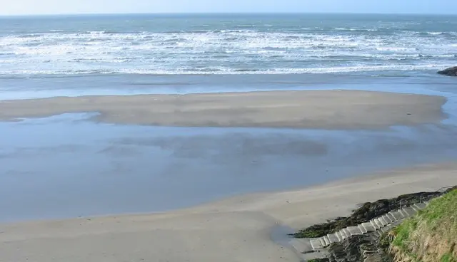 Steps overlooking sand and waves on Inchydoney East Beach.