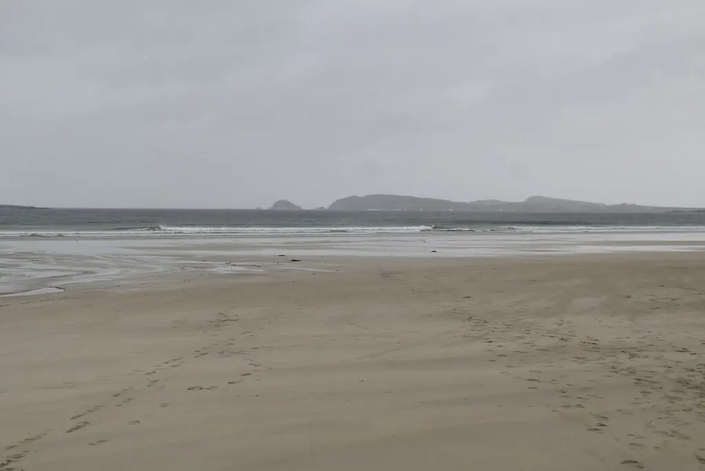 The broad sandy shore at Carrickfinn beneath an overcast sky.