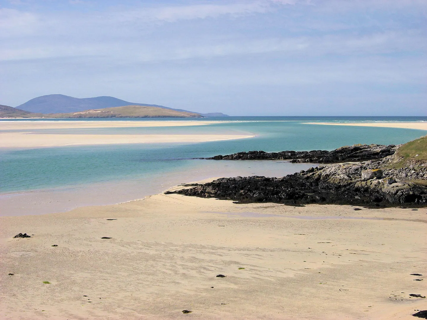 Pale sand, shallow turquoise water and distant hills at Luskentyre on Harris