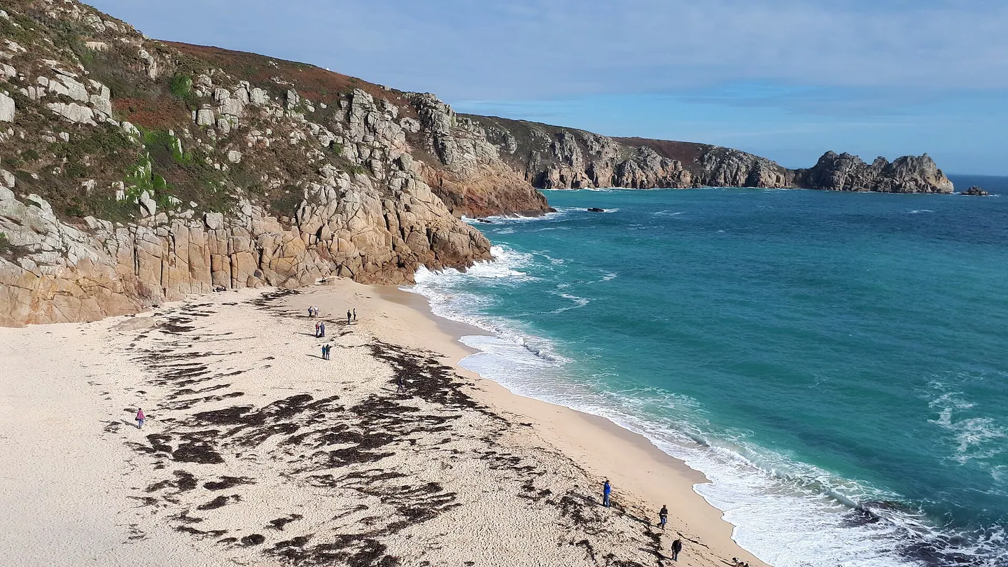 The sandy cove at Porthcurno beneath cliffs, with turquoise sea