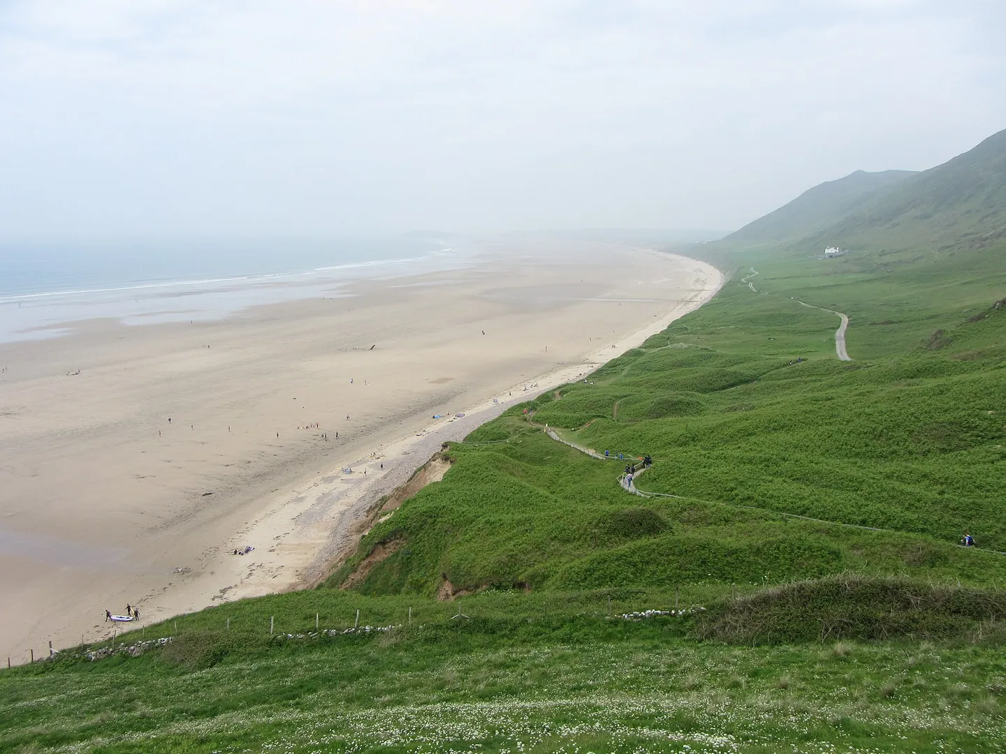 Rhossili Bay and its broad sandy beach seen from the grassy coast path