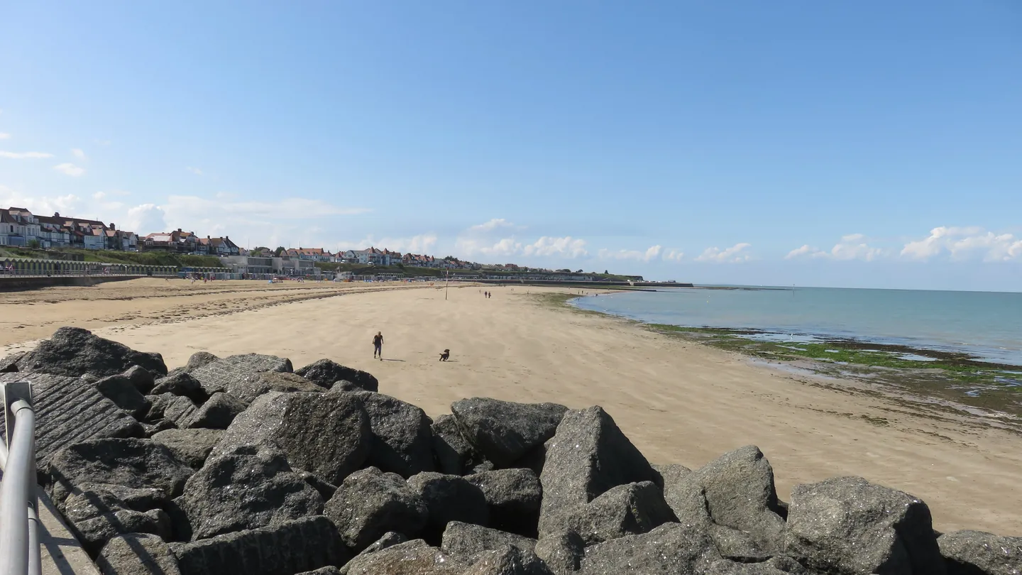 Westbrook Bay and its sandy beach seen past the sea-defence rocks